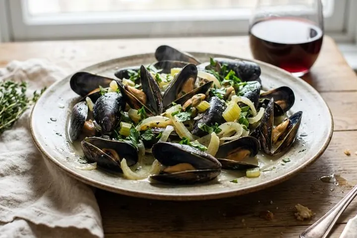 Une assiette de moules marinières à l’oignon et au persil.